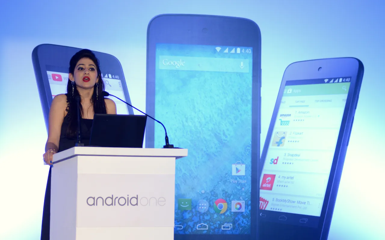 Presenter at the Android One launch with giant phone displays