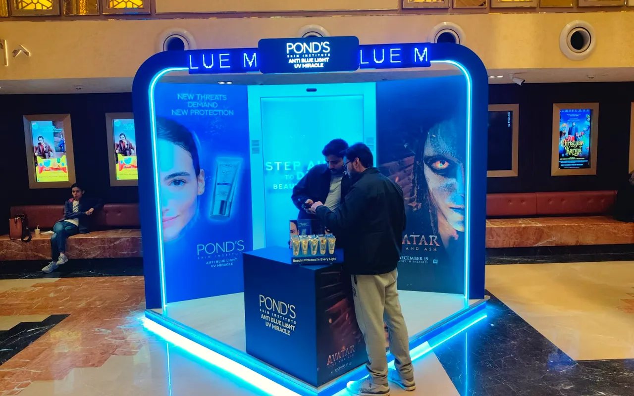Glowing blue Pond's mirror booth in a mall